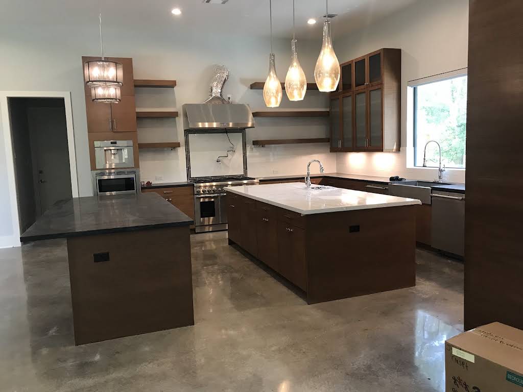 RM kitchen with wood cabinetry, two islands and glass-front upper cabinets.