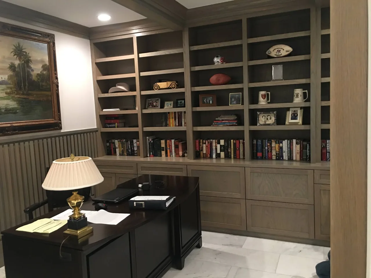 RM home office with a wall of wood bookshelves, lower drawers and a desk.